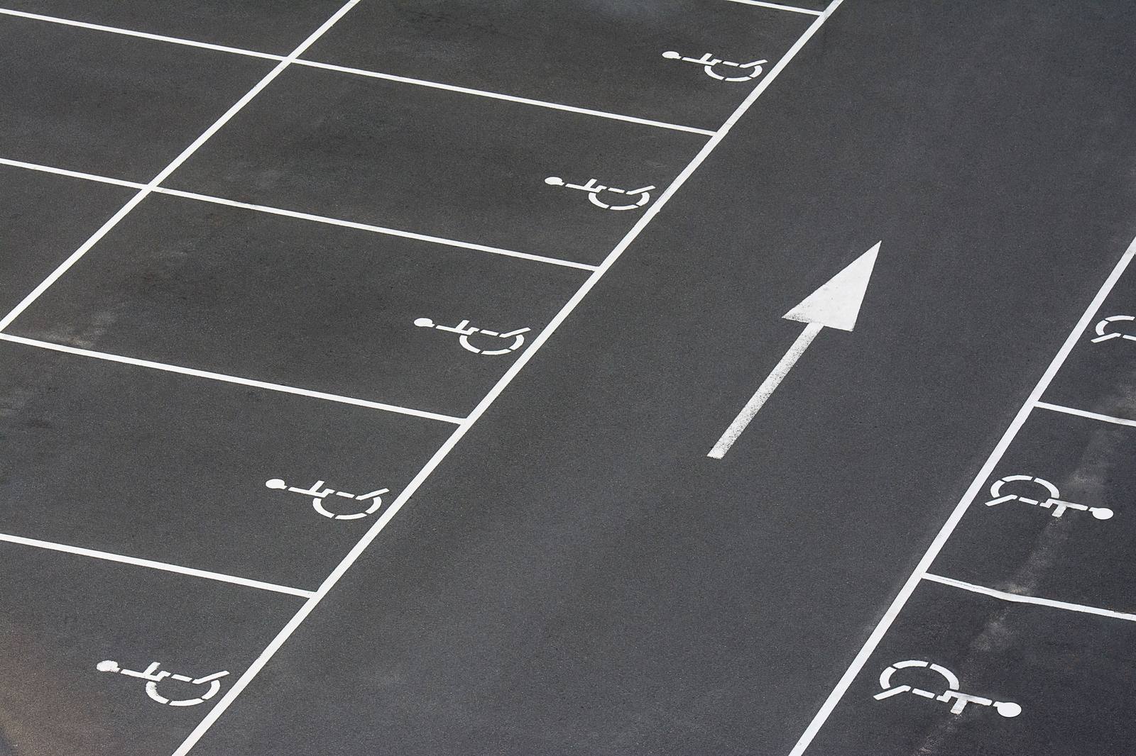 Accessible parking stalls marked with the accessibility symbol beside a directional arrow