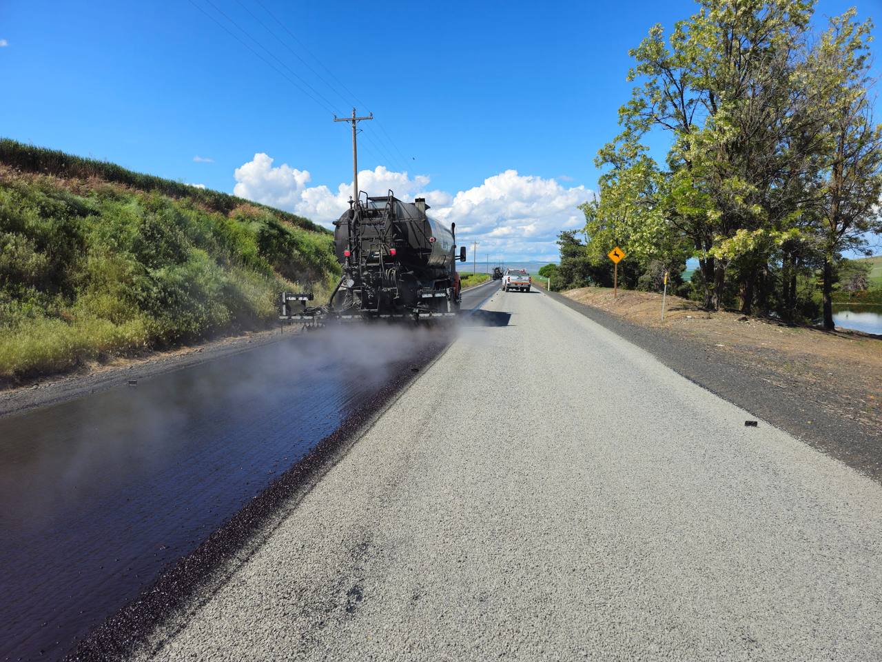 A new layer of asphalt being placed over a worn pavement surface