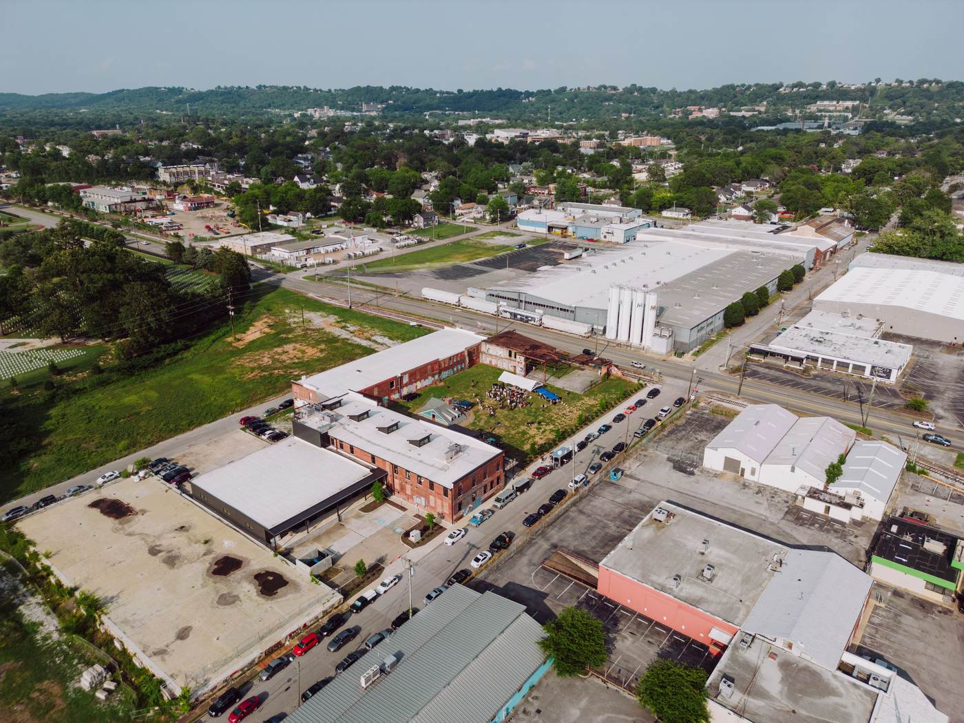 Aerial view of a dense industrial corridor with small business lots and street parking