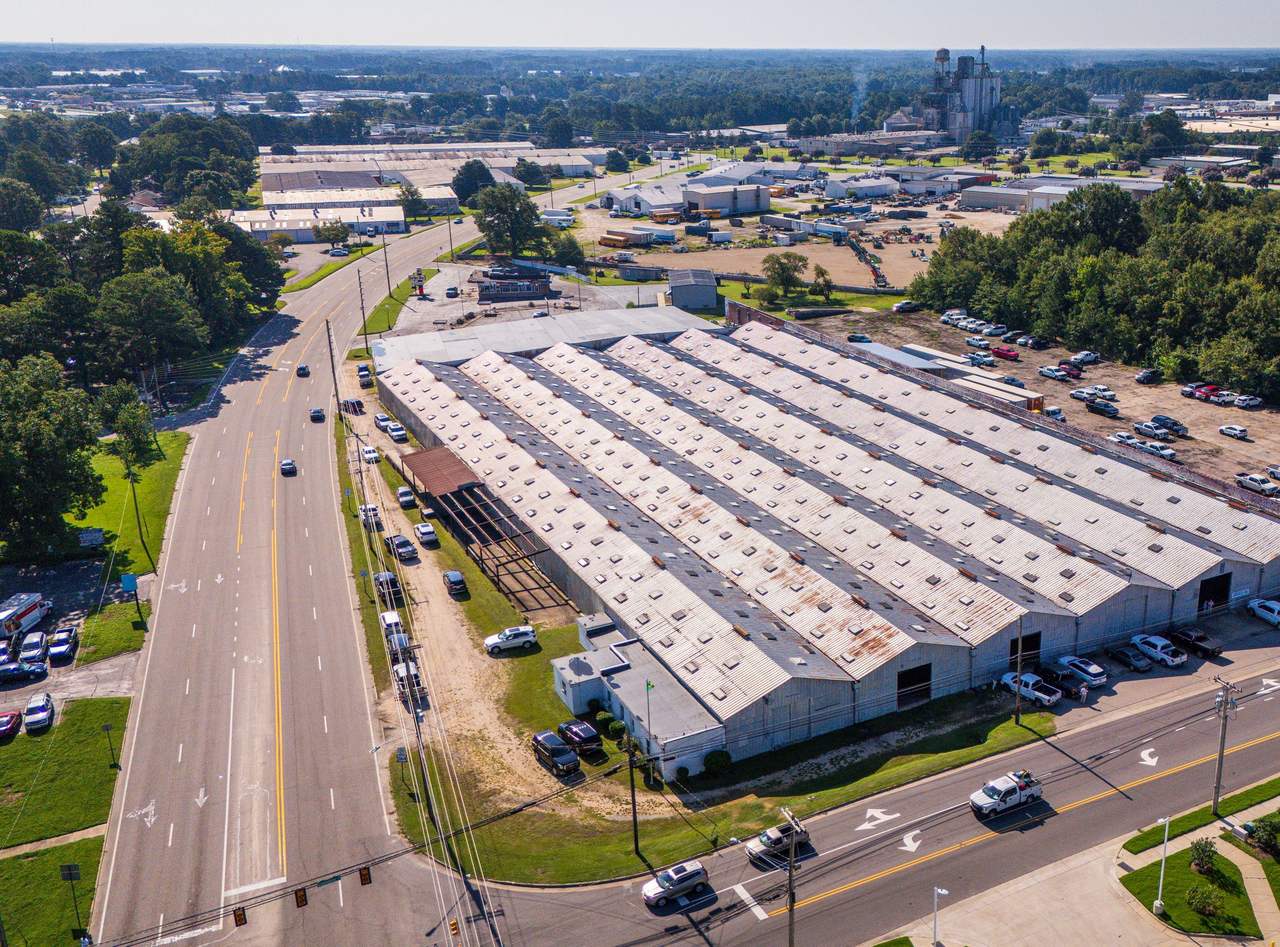 Aerial view of an industrial corridor lined with warehouses, paved yards and parking